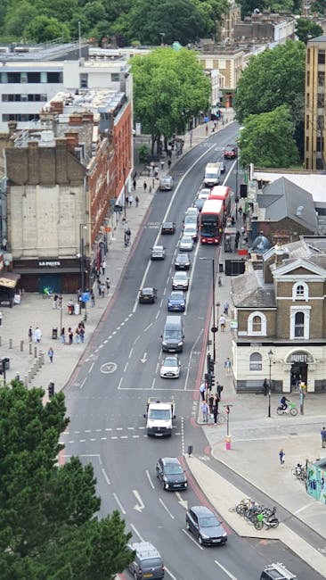 A white sign with a red London Underground roundel featuring a blue horizontal bar labeled 'EALING BROADWAY' positioned on the pavement at Ealing Broadway station. Above the sign, directional informat